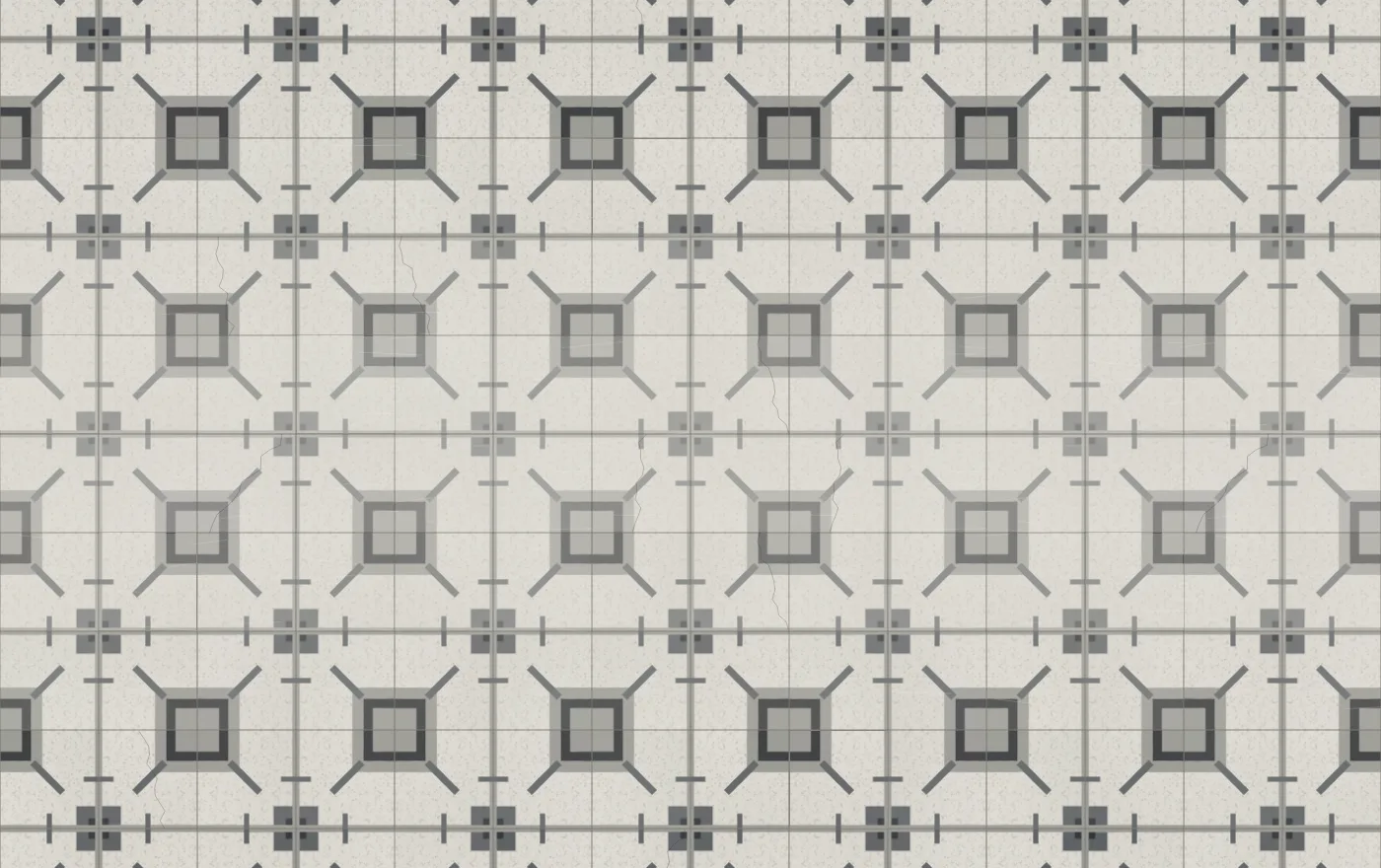 A grey cement floor of nested squares, paler and scuffed along a band through the middle where it has been walked, with a few cracks